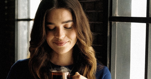A person at home with a cup of Heist decaf coffee
